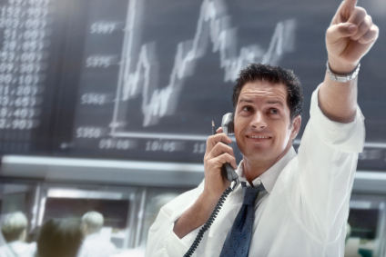 Financial analyst trading stocks in a busy office